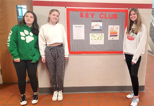 FHS Key Club students stand in front of bulletin board